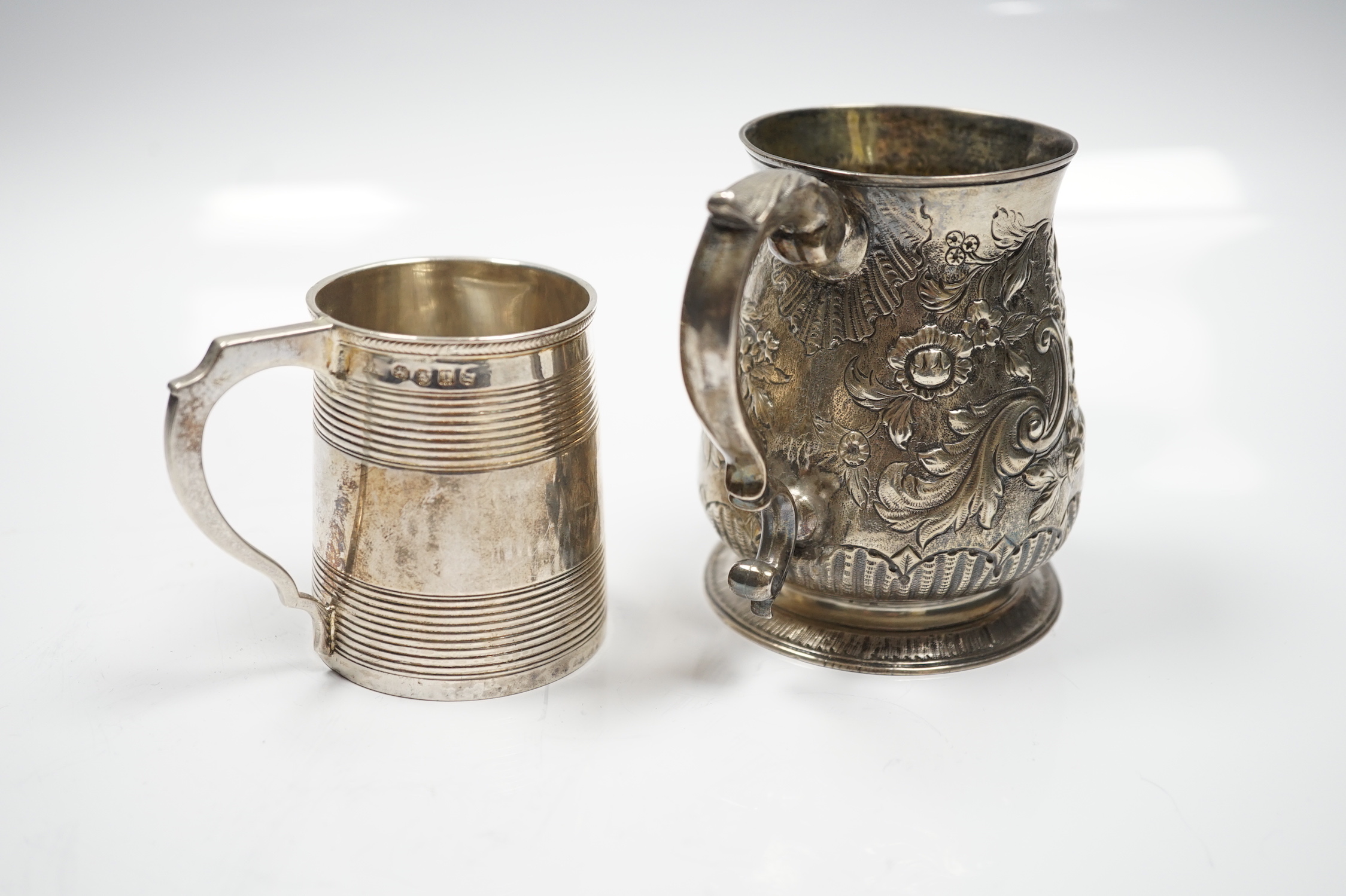 A late George II silver baluster mug, with later embossed decoration, William Shaw II?, London, 1756, 93mm, together with a George III reeded silver small christening mug, London, 1814.